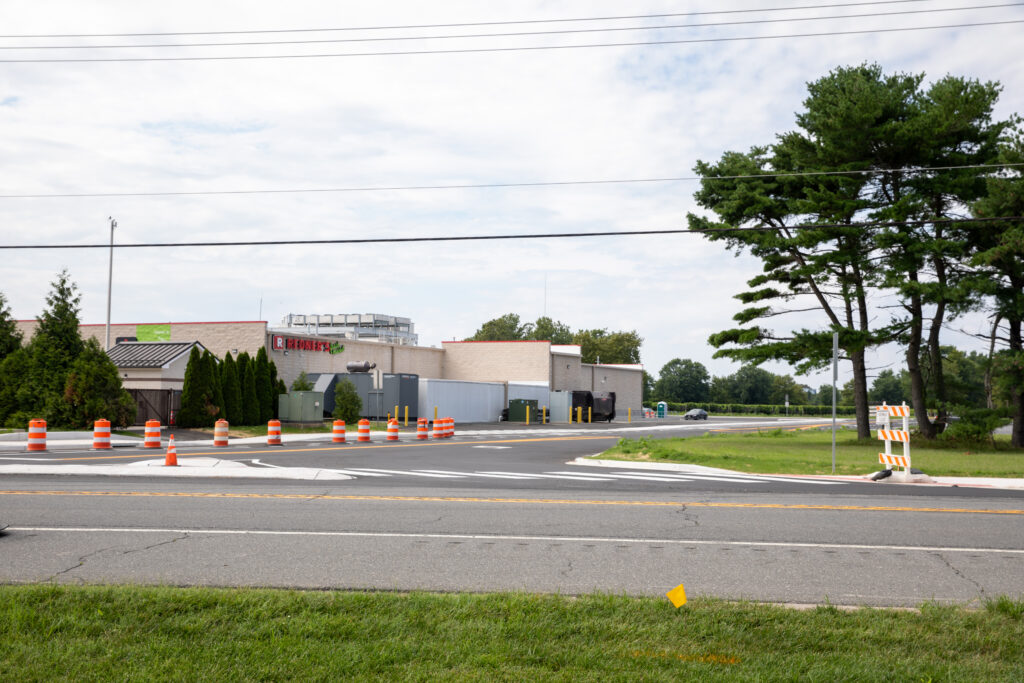 Newly opened Nassau Commons Boulevard in Sussex County, Delaware, featuring fresh pavement, road signage, and surrounding commercial development.