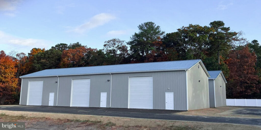 Warehouse buildings at 16727 Coastal Highway, Lewes, Delaware, surrounded by vibrant fall foliage with colorful autumn leaves, capturing a seasonal atmosphere